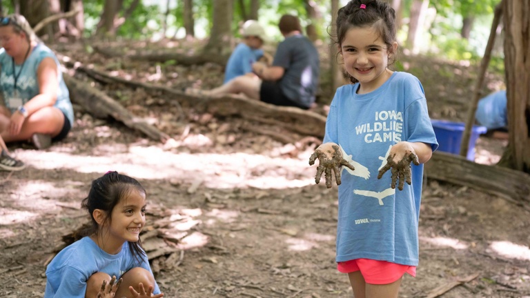 Iowa Wildlife campers pose with muddy hands 
